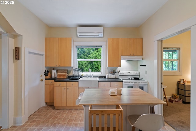 11151117 N Beech St, Portland, OR 97227 - kitchen with electric range, a wall mounted air conditioner, under cabinet range hood, light brown cabinetry, and a breakfast bar area