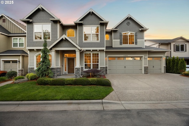11473 NW W Rd, Portland, OR 97229 - view of front facade with stone siding, driveway, an attached garage, and a yard