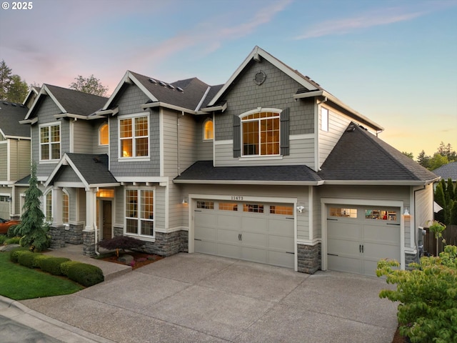 11473 NW W Rd, Portland, OR 97229 - craftsman-style home with stone siding, driveway, a garage, and a shingled roof