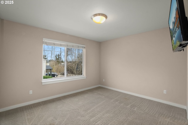 unfurnished room with carpet floors and baseboards