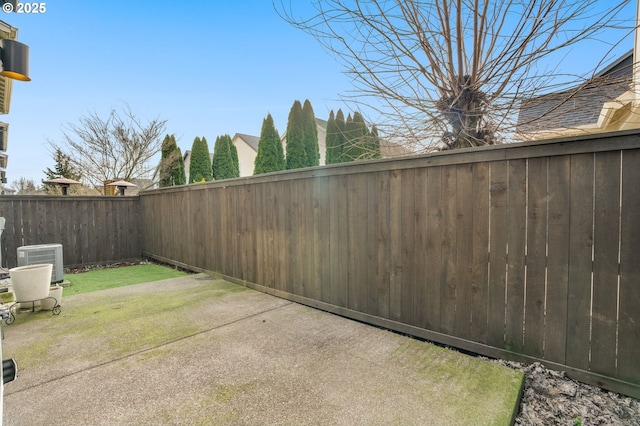 view of yard with central AC unit, a patio area, and a fenced backyard