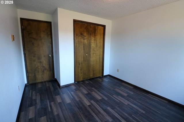 unfurnished bedroom with dark wood-type flooring and a textured ceiling