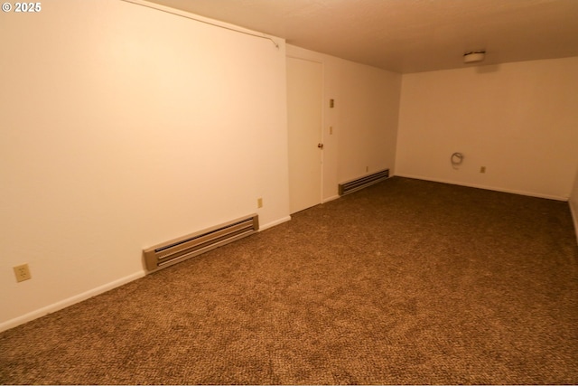 spare room with baseboard heating and dark colored carpet