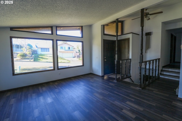 spare room with a textured ceiling, ceiling fan, and dark hardwood / wood-style floors