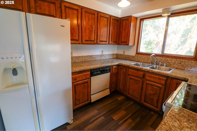 kitchen featuring white appliances, light stone counters, dark hardwood / wood-style flooring, and sink