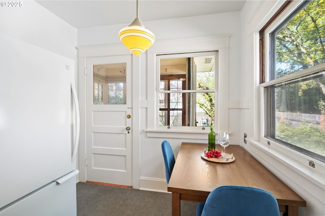 dining space with plenty of natural light and carpet floors