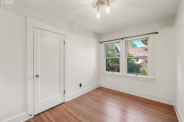 unfurnished bedroom featuring wood finished floors and baseboards