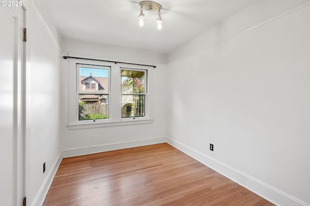spare room featuring light wood-style flooring and baseboards