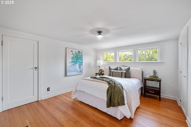 bedroom featuring light wood-type flooring and baseboards