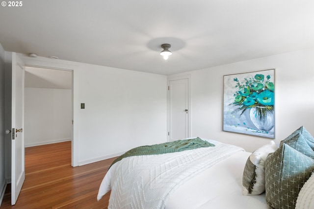 bedroom featuring baseboards and wood finished floors