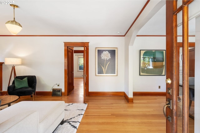 bedroom with light wood finished floors, baseboards, and ornamental molding