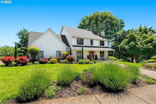 view of front of home with a porch, a shingled roof, a front yard, and a chimney