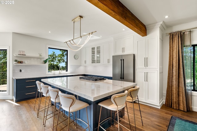 kitchen featuring a healthy amount of sunlight, white cabinetry, and wood finished floors