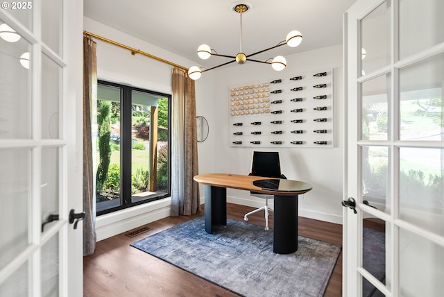 unfurnished office with a notable chandelier, french doors, baseboards, wood finished floors, and visible vents