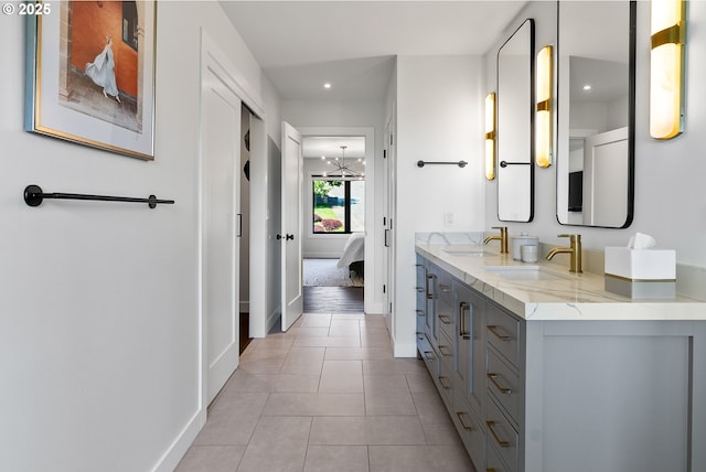 ensuite bathroom featuring a sink, baseboards, ensuite bathroom, and recessed lighting