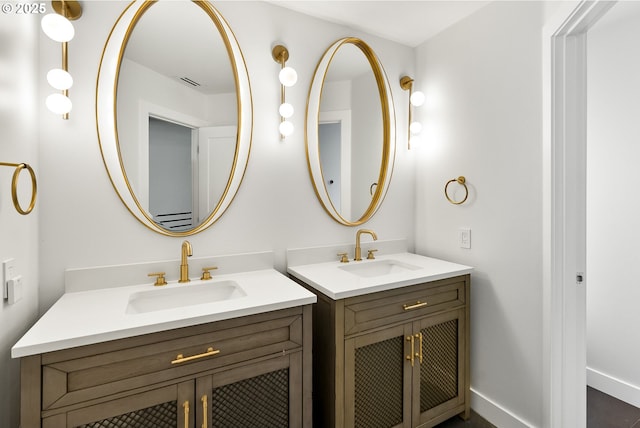 full bathroom with a sink, baseboards, visible vents, and two vanities