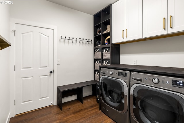laundry room with cabinet space, dark wood-style flooring, and washing machine and dryer