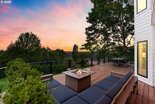wooden deck with outdoor dining area and an outdoor fire pit