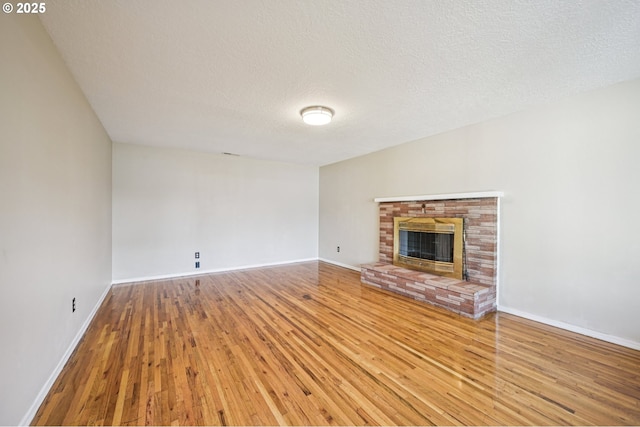 1631 N Clark St, Cornelius, OR 97113 - unfurnished living room featuring wood-type flooring, a fireplace, and a textured ceiling