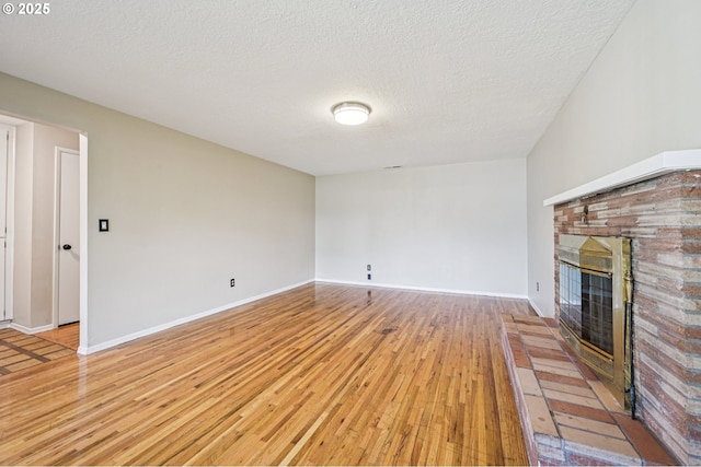 1631 N Clark St, Cornelius, OR 97113 - unfurnished living room featuring light wood-type flooring, a glass covered fireplace, and a textured ceiling