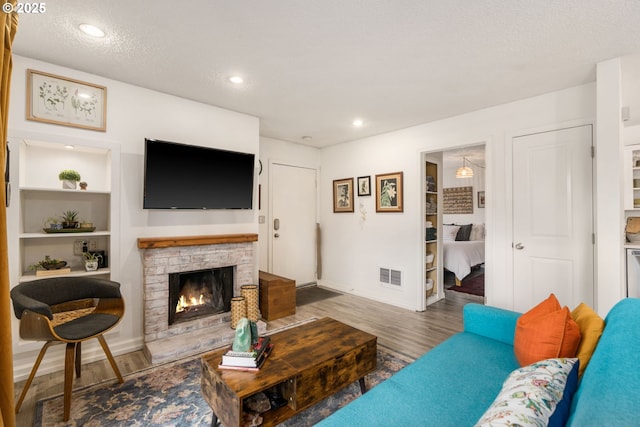 7538 SW Barnes Rd Unit H, Portland, OR 97225 - living room with a lit fireplace, wood finished floors, baseboards, recessed lighting, and built in features