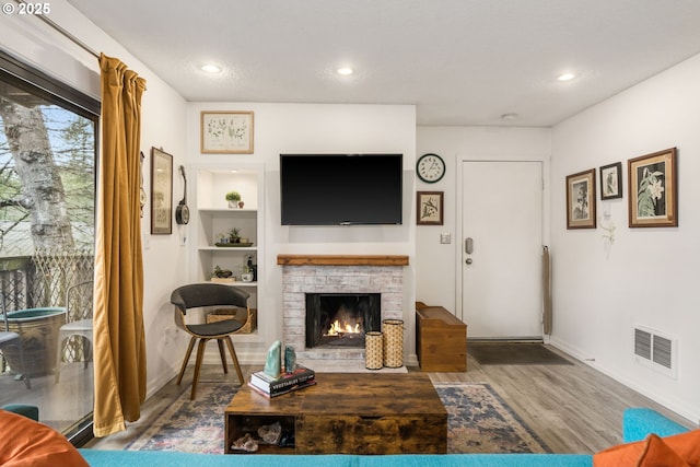 7538 SW Barnes Rd Unit H, Portland, OR 97225 - living area with wood finished floors, a warm lit fireplace, baseboards, and recessed lighting