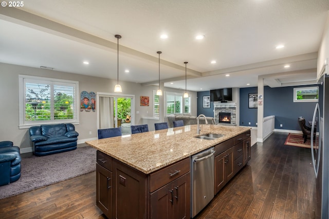 13864 SE Nightingale Ave, Happy Valley, OR 97015 - kitchen with open floor plan, stainless steel appliances, a fireplace, dark wood-style flooring, and light stone countertops