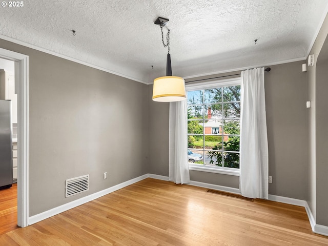 4561 NE 35th Ave, Portland, OR 97211 - unfurnished dining area with a textured ceiling, crown molding, and light wood-style floors