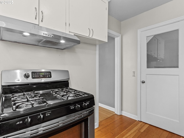 4561 NE 35th Ave, Portland, OR 97211 - kitchen featuring stainless steel gas stove, under cabinet range hood, white cabinetry, and light wood-style flooring