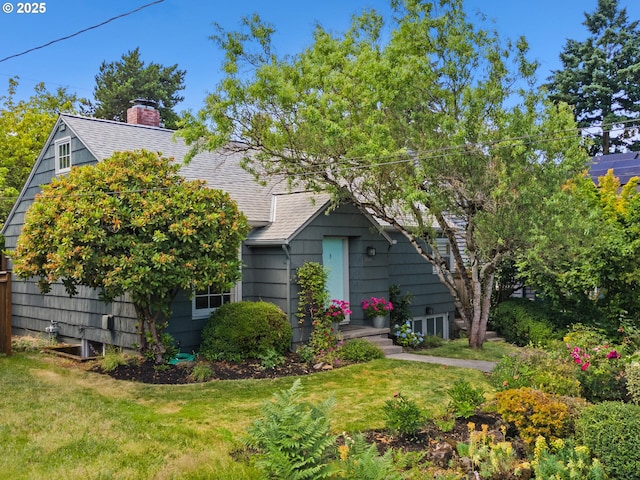 4561 NE 35th Ave, Portland, OR 97211 - view of property hidden behind natural elements with a shingled roof, a front lawn, and a chimney