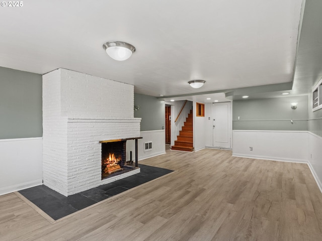 4561 NE 35th Ave, Portland, OR 97211 - unfurnished living room with wood finished floors, a brick fireplace, stairs, and recessed lighting