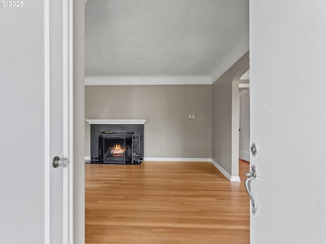 4561 NE 35th Ave, Portland, OR 97211 - unfurnished living room with wood finished floors, a lit fireplace, a textured ceiling, and ornamental molding