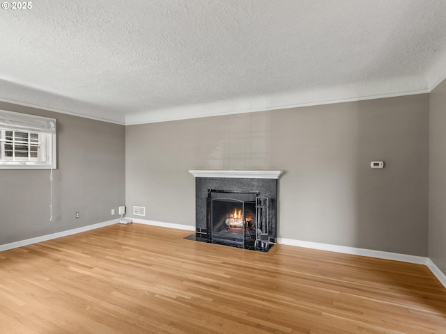 4561 NE 35th Ave, Portland, OR 97211 - unfurnished living room featuring a premium fireplace, a textured ceiling, light wood-style flooring, and ornamental molding