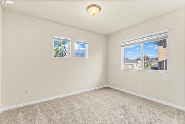 empty room featuring baseboards and carpet