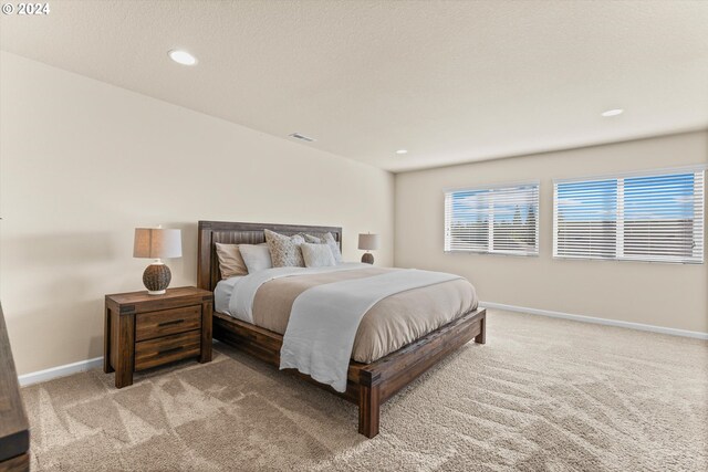 bedroom with recessed lighting, light colored carpet, visible vents, and baseboards