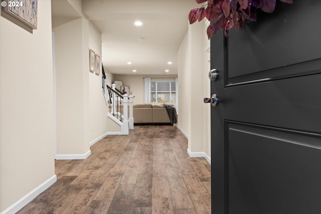 hall featuring stairs, wood finished floors, and baseboards