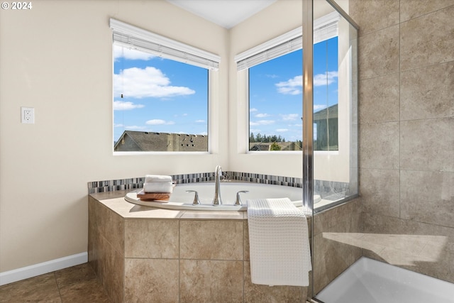 bathroom featuring tile patterned floors, baseboards, and a bath