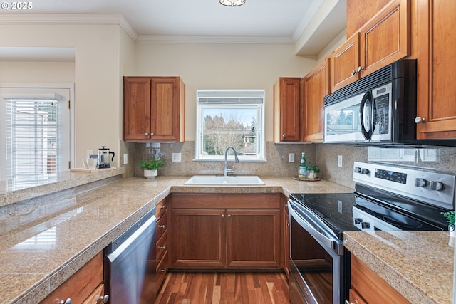 kitchen featuring tile countertops, brown cabinets, appliances with stainless steel finishes, and a sink