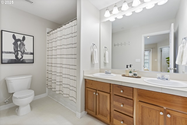 full bathroom with a sink, baseboards, toilet, and double vanity