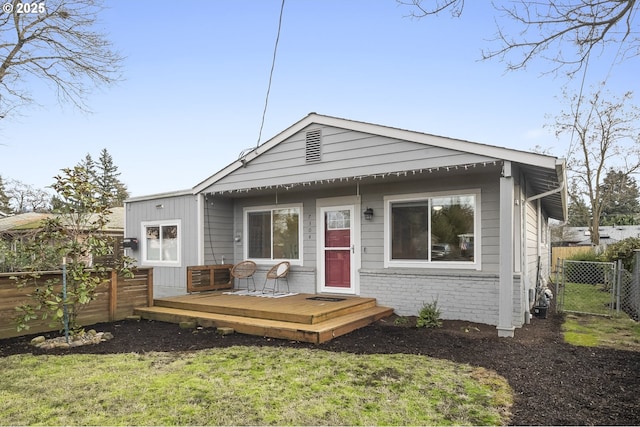 view of front facade with a deck and a front lawn