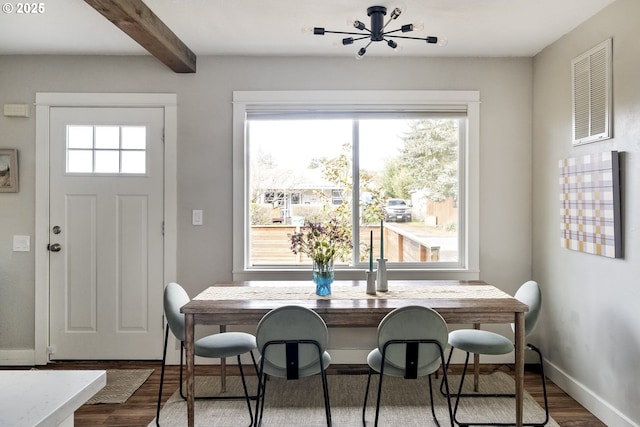 dining room with hardwood / wood-style flooring and beamed ceiling