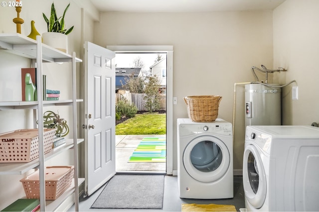 clothes washing area featuring water heater and independent washer and dryer