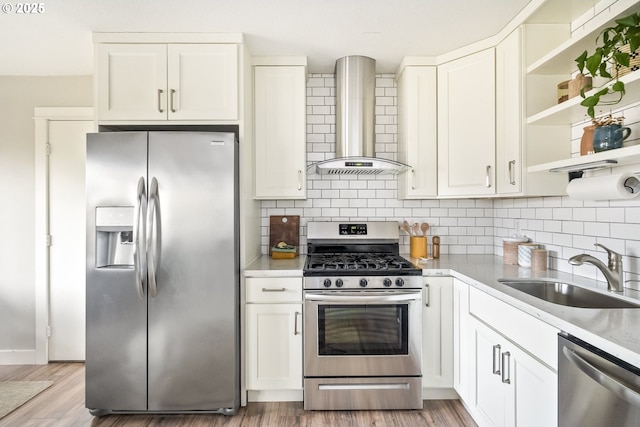 kitchen with sink, wall chimney range hood, stainless steel appliances, light hardwood / wood-style floors, and white cabinets