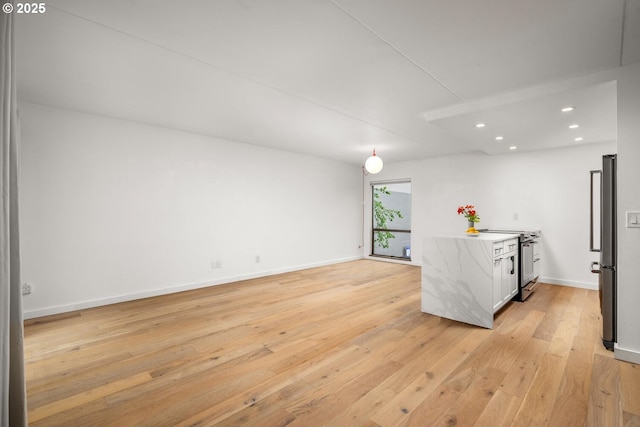 1919 NW Hoyt St Unit 104, Portland, OR 97209 - kitchen with high end stainless steel range oven, light wood-style flooring, recessed lighting, light countertops, and white cabinetry