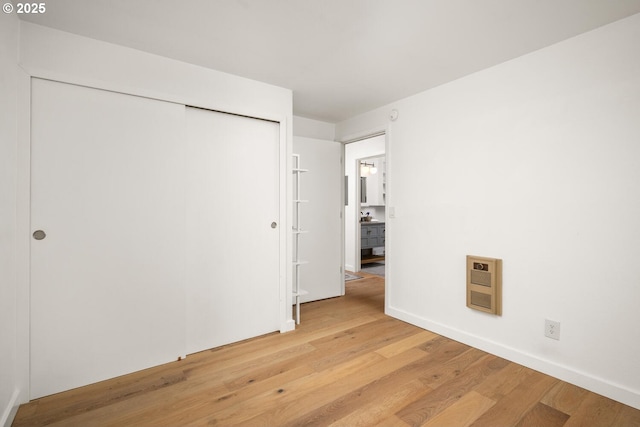 1919 NW Hoyt St Unit 104, Portland, OR 97209 - unfurnished bedroom with light wood-type flooring, heating unit, and a closet