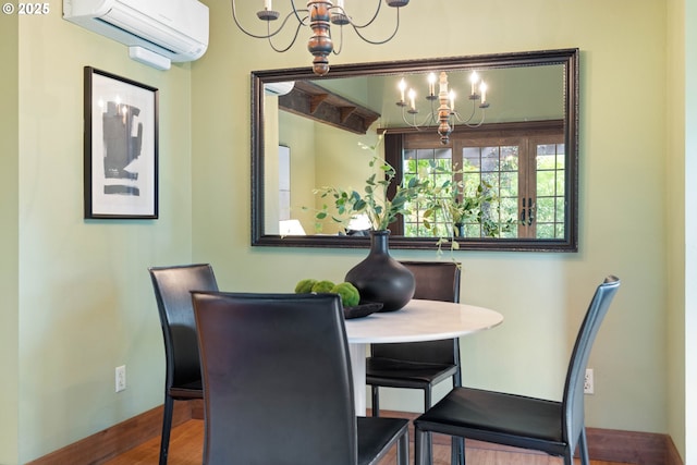 15787 SW Village Cir, Beaverton, OR 97007 - dining room featuring a chandelier, an AC wall unit, baseboards, and wood finished floors