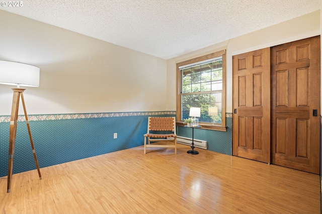 15787 SW Village Cir, Beaverton, OR 97007 - unfurnished room with wainscoting, a baseboard radiator, wood finished floors, and a textured ceiling