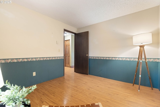 15787 SW Village Cir, Beaverton, OR 97007 - empty room with a wainscoted wall, wood finished floors, and a textured ceiling
