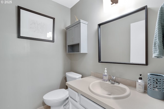 half bathroom featuring vanity and toilet