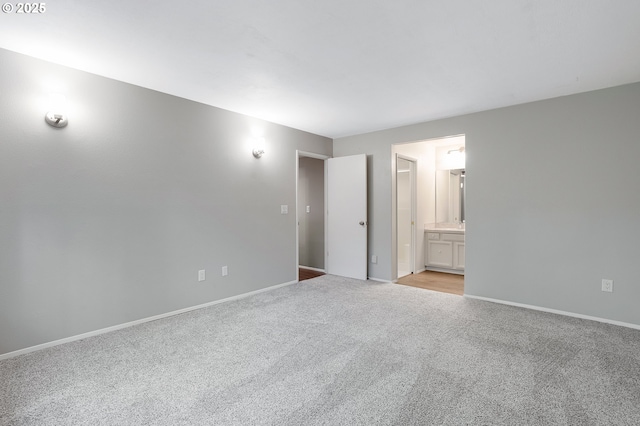 spare room featuring baseboards and light carpet